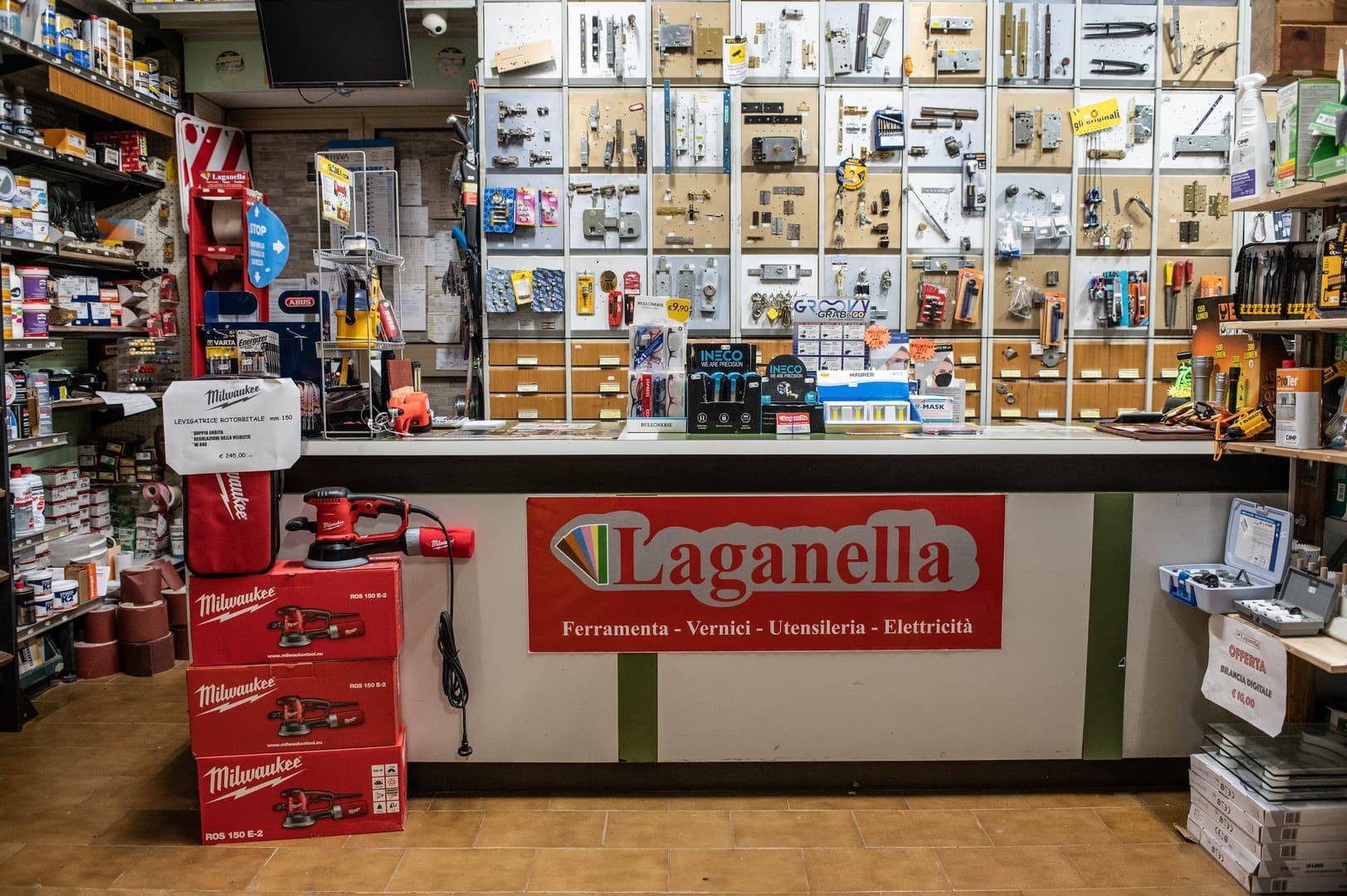 Il banco del negozio con il logo Laganella e, dietro, la parete degli articoli